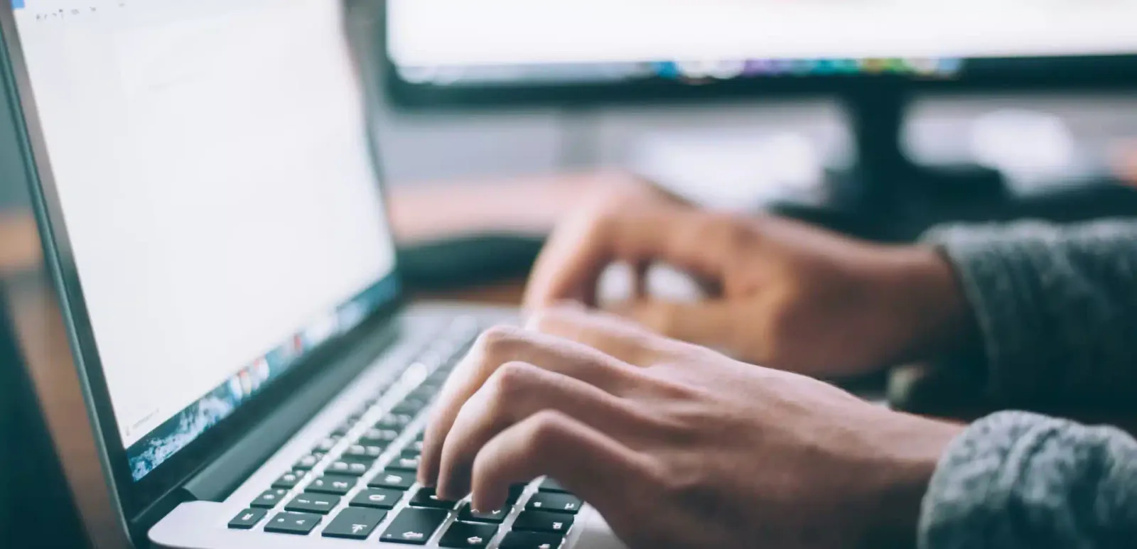 a man tapping on his keyboard to research the benefits of carbon footprint calculator