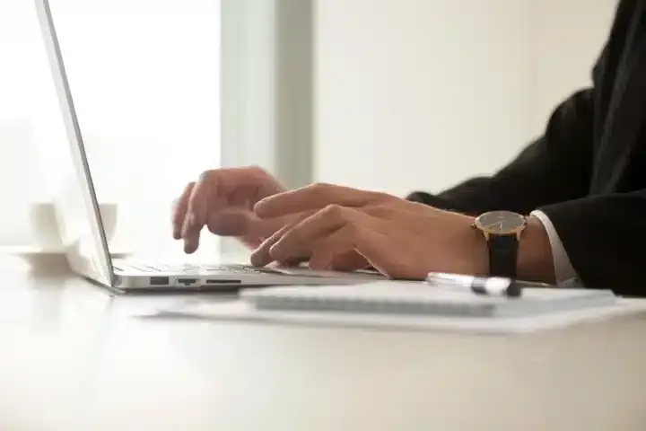 A man typing on his keyboard to create his Scope 3 emissions report